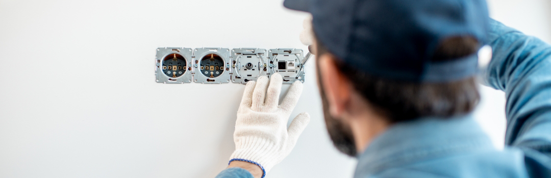 A handyman completes electric work in a home.