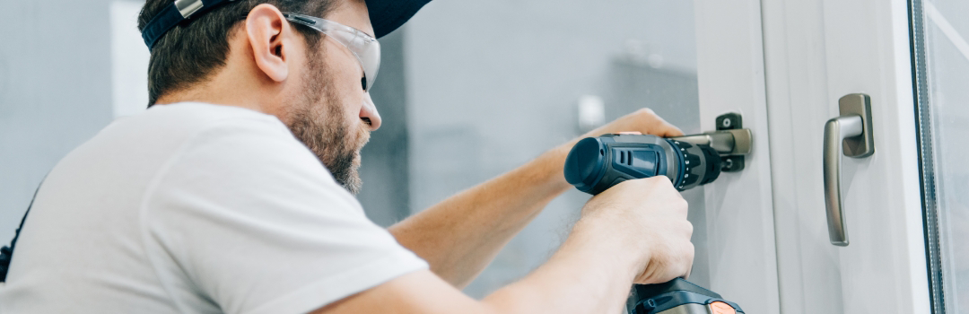 A local handyman installs doors in a home.